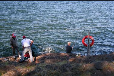 PEOPLE FISHING NEAR LIFE-RING