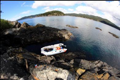 anchored with exposed reefs in background