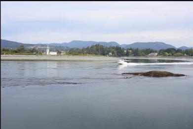 boat going through narrows behind reef